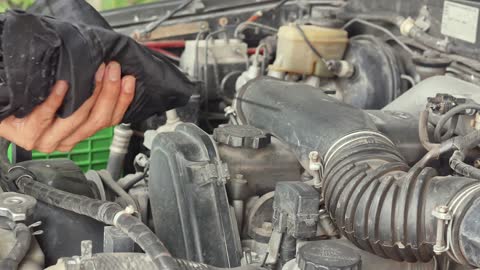 Mechanic Checking The Level Of A Car Engine Oil.