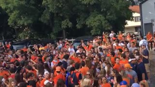 Guy orange shirt throwing beer at crowd and guy catching it