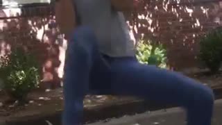 Girl in grey shirt tries to hold unto tree branch but its breaks and she falls