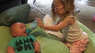 Hermana mayor ayuda a su hermanito bebé