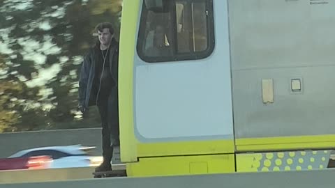 Train Hopping Fellow Waves to Traffic