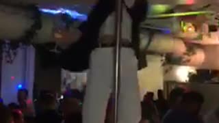 Blonde woman spins on pole falls on people