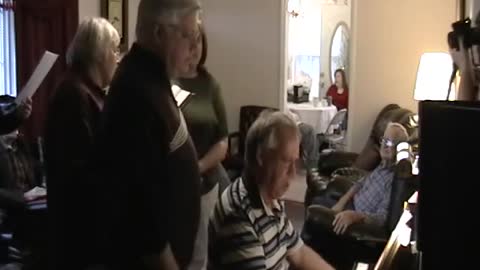 Family gather around the piano for an ole Gospel song