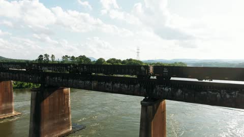 A Train Trams Crossing A Railroad Bridge Over A River