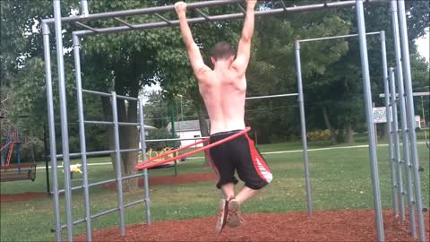 Talented athlete does pull-ups while hula hooping