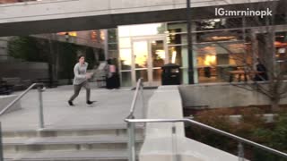 Grey hoodie kid tries to do sideflip on concrete steps lands on barrier