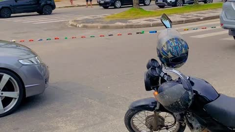 Train of Toy Cars Pulled Down the Street by Cyclist