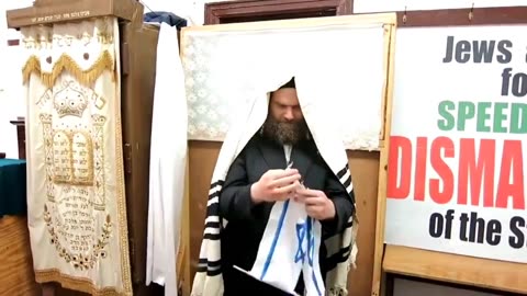 Anti-Zionist Jewish Rabbi tearing the Israeli flag in the Synagogue