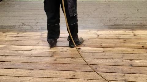 Hard work power washing a deck for stain