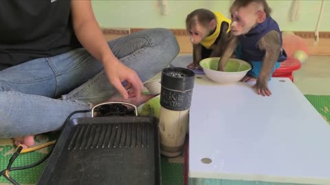 Mimi Kuku holds a bowl and waits for her Mom to fry the cake