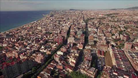 aerial view of barcelona with dense house development and the coast the second
