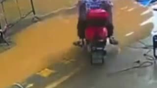 Solo en China: una mujer en moto se hunde al intentar atravesar un charco