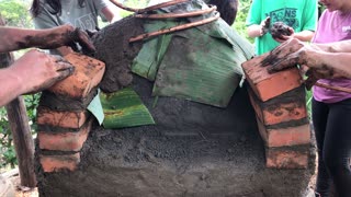 Formando la puerta de un horno de barro.