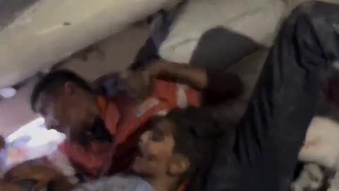 A child screaming as rescue teams attempt to pull him out from under the rubble.