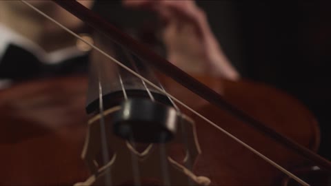 Close Up Hands And Bow Of Male Cellist Playing Cello