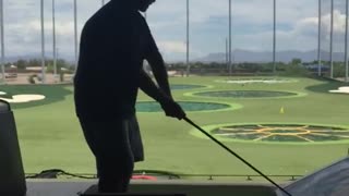 Golfer tries happy gilmore swing from second level of driving range and falls over edge