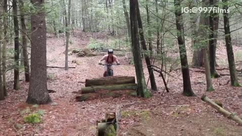 Forest man in pink shirt on bike falls off slides on dirt