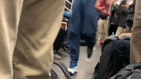 Guy swings and flips on subway train ceiling handrails and slides upside down