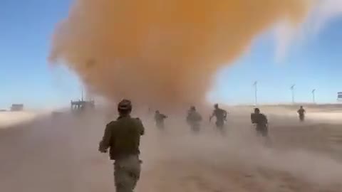 IDF combat soldiers run toward a massive Dust Devil (Sand tornado).