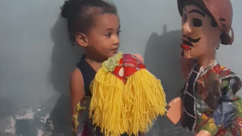 Mestre Bila playing with his daughter with Simão doll