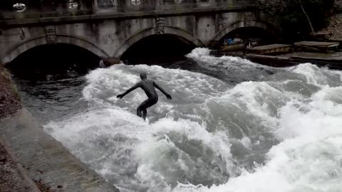 Surfer surfing the city's river - high adrenaline