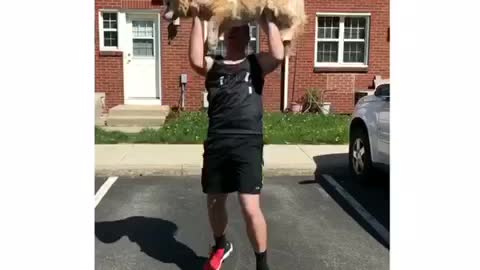 Guy reenacts lifting with his dog.