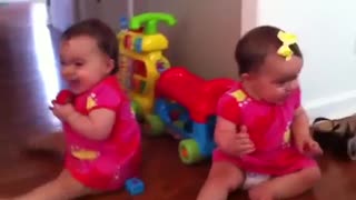 Bebas gemelas se ríen como locas al ver a su perro haciendo trucos