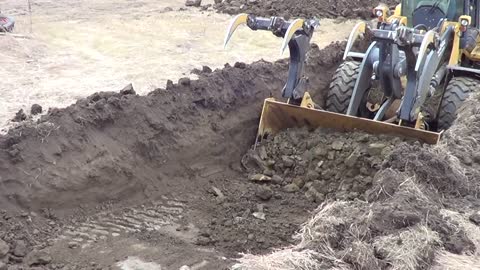 John Deere 624k high lift digging garbage hole