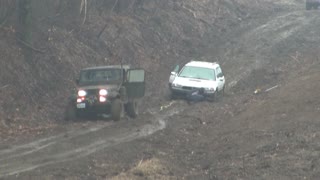 Jeep Backing Up in Mud To Tow Out Subaru