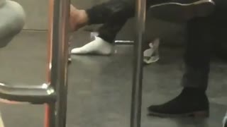 Man barefoot in subway train
