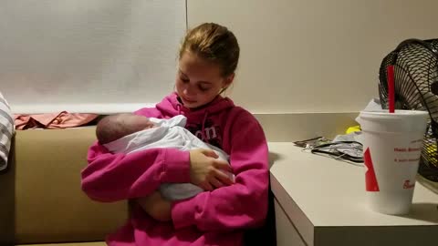 Emocionada hermana mayor sostiene a su hermanito bebé por primera vez
