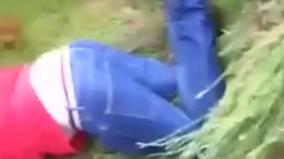 Guy in red sweatshirt is lying down facedown in grass