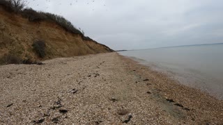 Hiking on a beach with high cliffs. Speedlapse