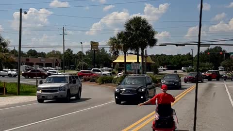 Elderly Couple with Scooters Holding up Bridge Traffic