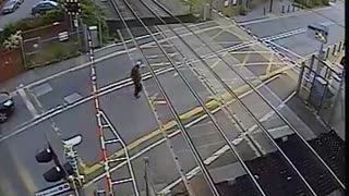 Shocking moment man nearly gets hit by speeding train after lifting barrier
