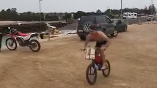 Guy rides his bike off a ramp into a lake