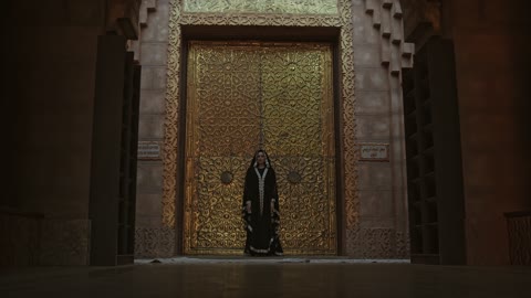 A Woman Standing In Front Of A Bronze Door