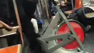 Man rides indoor exercise bike on subway train