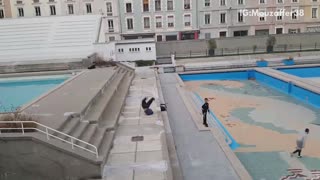 Three friends do parkour in empty pool deck, guy back flips and fails
