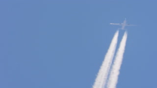 Airplanes drawing white lines in the sky.