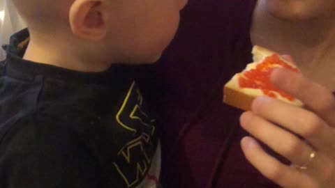 Boy eating a sandwich with red caviar