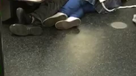 Couple falls asleep on the corner of the floor inside subway train