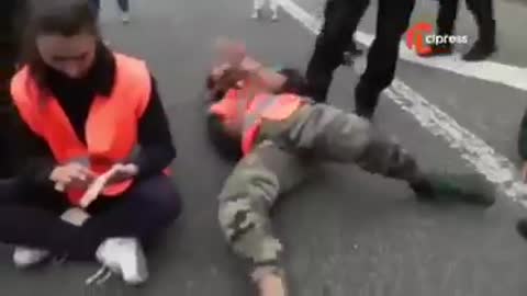 French activist pretends he's been hurt when a police officer tries to lift him from the floor