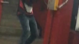 Guy black red shirt hat dancing subway hands