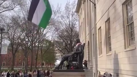 Harvard students cheer as they replace an American Flag with a Palestinian Flag.