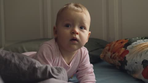 Restless baby smiling at the camera