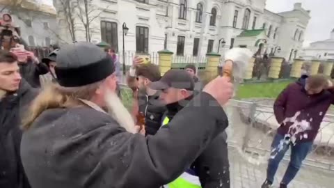In the Lavra, a male priest sprinkled satanic journalists with holy water.