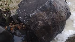 Water flowing around rock