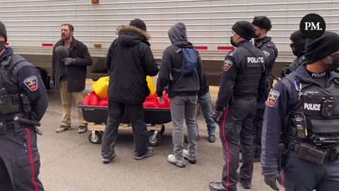 Freedom protestors in Ottawa sing O Canada while police talk to some who were transporting fuel for the truckers