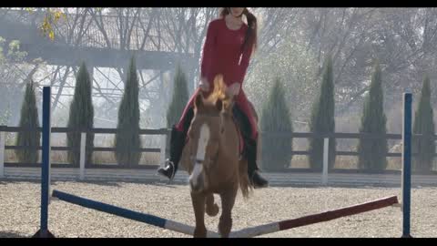 Young Caucasian female equestrian in helmet and pink clothes